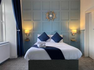 a bedroom with a large bed with blue walls at Marina View Guest House in Irvine