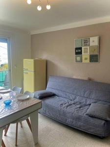 sypialnia z niebieskim łóżkiem i stołem w obiekcie Appartement T2 lumineux, moderne avec parking et wifi - 4SABLE16 w mieście Canet-en-Roussillon