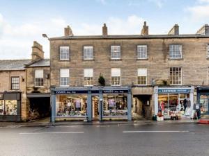 an old brick building with shops in front of it at Pass the Keys The Eaves Style & Sophistication Central Bakewell in Bakewell
