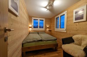 ein Schlafzimmer mit einem Bett und einem Sofa in einem Zimmer in der Unterkunft Imhof Alpine B&B Apartments in Bettmeralp