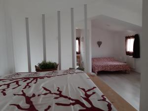 um quarto com uma cama com um cobertor vermelho e branco em La Casetta em Vittorio Veneto