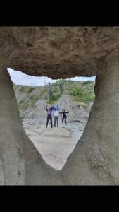 un grupo de tres personas de pie en una cueva en Hostal Makesa Tatacoa, en Villavieja