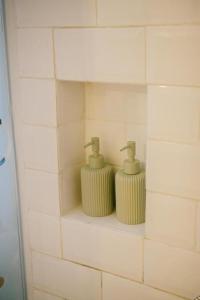 a bathroom with two soap dispensers on a wall at Casa Amarta - Canggu in Canggu