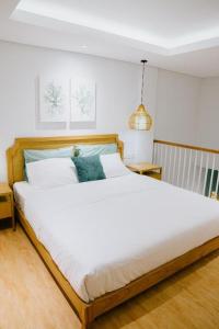 a bedroom with a large white bed in a room at Casa Amarta - Canggu in Canggu