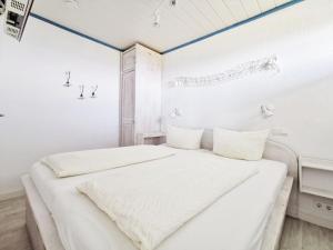 ein weißes Schlafzimmer mit 2 Betten und einem Fenster in der Unterkunft Haus Nordseeblick Nordseeblick, 1 in Norderney