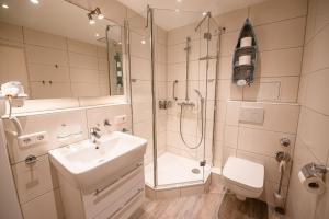 ein Bad mit einer Dusche, einem Waschbecken und einem WC in der Unterkunft Haus Nordseeblick Nordseeblick, 1 in Norderney