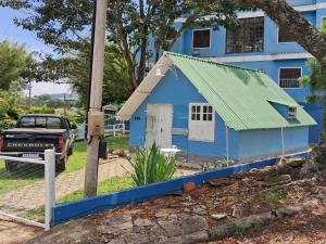 a blue house with a green roof at Meu Chalé in Miguel Pereira