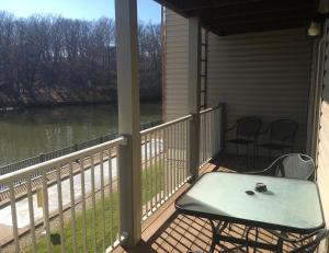 a porch with a table and chairs and a view of a river at Lake View Condo with Heated Pool and Hot Tub close to Grand Glaize Bridge at Lake Ozarks in Osage Beach
