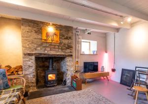 a living room with a stone fireplace at Ty Newydd - a scandi inspired cottage in Moylgrove
