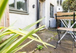 a wooden bench in front of a house at Ty Newydd - a scandi inspired cottage in Moylgrove