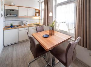 a kitchen with a wooden table and chairs at Haus Regina Maris, Wohnung 7 in Norderney