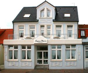 un edificio blanco con techo negro en Haus Regina Maris, Wohnung 7 en Norderney