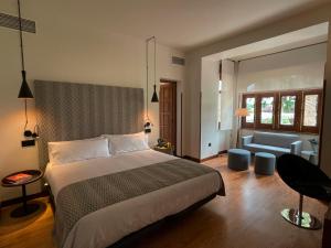 a bedroom with a bed and a living room with a couch at Hotel El Rosal de Cudillero in Cudillero
