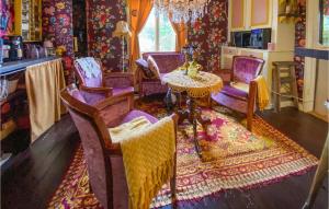 a living room with purple chairs and a table at Nice Home In Grimmered With House A Panoramic View 