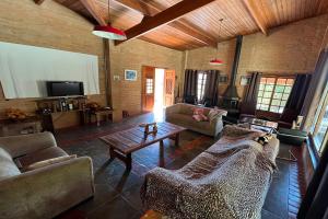 a living room with couches and a table and a tv at Estância Village de Cunha in Cunha