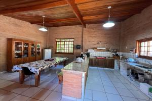 a large kitchen with a table and a refrigerator at Estância Village de Cunha in Cunha