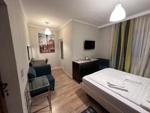 a bedroom with a bed and a chair and a desk at Pensiunea Saseasca in Lereşti