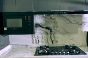 uma cozinha com um fogão e um micro-ondas em aPogee Home em Abuja