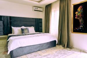 um quarto com uma cama e um quadro na parede em aPogee Home em Abuja