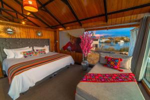 a bedroom with a bed and a window and a couch at KAY PACHA LODGE lago titicaca All Inclusive in Puno