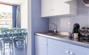 a kitchen with a sink and a table with chairs at El Trull Apartaments in Lloret de Mar