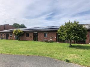 a brick building with a grass yard in front of it at Formby Point in Liverpool