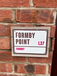 a sign on the side of a brick wall at Formby Point in Liverpool