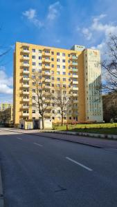 a large yellow building on the side of a road at Apartament z widokiem na las in Sopot
