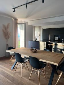 una sala da pranzo con un grande tavolo in legno e sedie di Lake View Homestay with Private Room and Bathroom a Châtillon