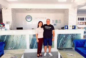 a man and a woman standing in front of a counter at Meduza Hotel in Olimp
