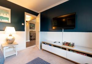 a living room with a tv on a blue wall at Ty Od in Pembrokeshire