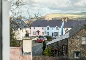 a row of houses in a village with a red car at Ty Od in Pembrokeshire