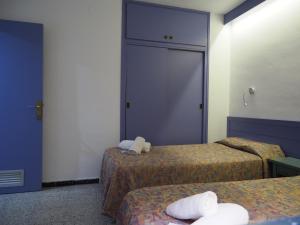 a room with two beds with towels on them at El Trull Apartaments in Lloret de Mar