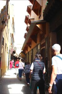 a group of people walking down a narrow street at Maison Moussaoui in Meknès