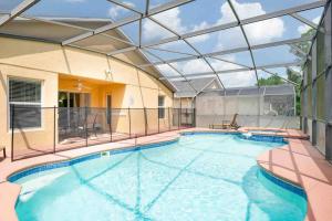 una grande piscina con soffitto in vetro di Vacation King Bed Home w Pool & Game room, near Disney a Davenport