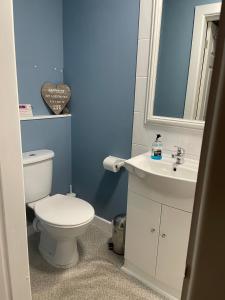 ein Badezimmer mit einem weißen WC und einem Waschbecken in der Unterkunft Another Place in Formby