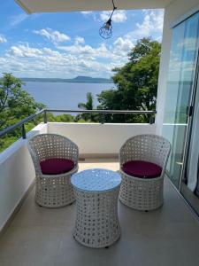 two chairs and a table on a balcony with a view of the water at Departamento céntrico con la mejor vista. San Bernardino in San Bernardino