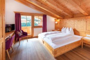 a bedroom with a large bed and a tv at Gästehaus Larch in Alpbach