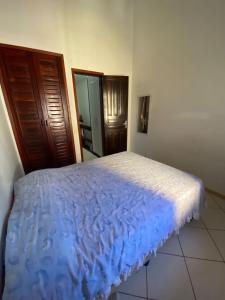 a bedroom with a bed with a blue comforter at Casa em Cond. a 80m da Praia do Peró in Cabo Frio +5 photos