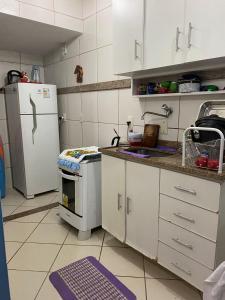 a kitchen with a white refrigerator and a stove at Casa em Cond. a 80m da Praia do Peró in Cabo Frio