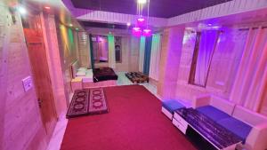 una stanza con una stanza rosa con un divano e una stufa di Majestic Mountain Bhaiji Guest House a Kasol Altre 113 foto