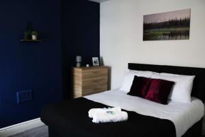 una camera da letto con un letto e un asciugamano bianco di FREE Parking - 5 Beds - Near Hospital a Warrington