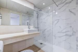 y baño blanco con lavabo y ducha. en apartamento con garaje en ensanche de vallecas, en Madrid