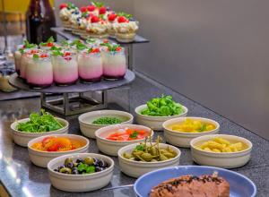 un buffet lleno de diferentes tipos de comida en un mostrador en Hotel Anders en Stare Jabłonki