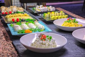 ein Buffet mit Speisen und Schüsseln in der Unterkunft Hotel Anders in Stare Jabłonki