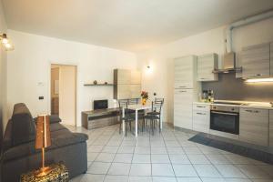 sala de estar y cocina con sofá y mesa en Suite il Borgo [Monza - Milano] + Garage Privato, en Desio