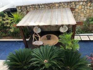 a wooden picnic table in a garden with plants at Mandai Apartamentos in Cabo Frio