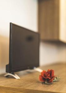 una flor en una mesa junto a un monitor de ordenador en Suite il Borgo [Monza - Milano] + Garage Privato, en Desio