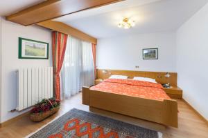 a bedroom with a bed and a large window at Hotel Panorama in San Martino di Castrozza
