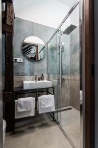 LANTerna Boutique Hotel في Srbac: حمام مع حوض ومرآة
